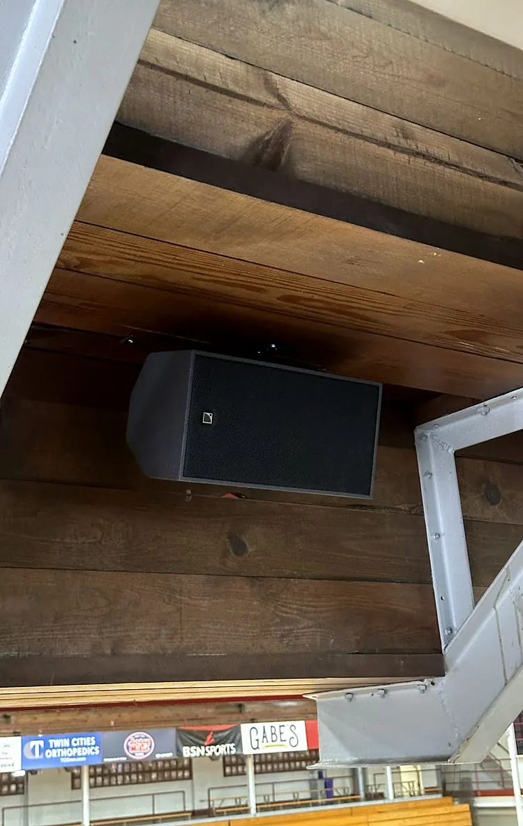 An L-Acoustics X6i fill loudspeaker mounted under the timber overhang at Hutton Arena