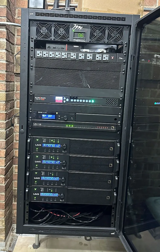 The Hutton Arena equipment rack with an Allen & Heath AHM-32, Shure wireless, an L-Acoustics LA1.16i and four LA4X amplifiers